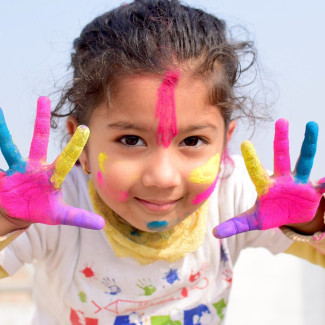 Kind mit buntbemalten Händen